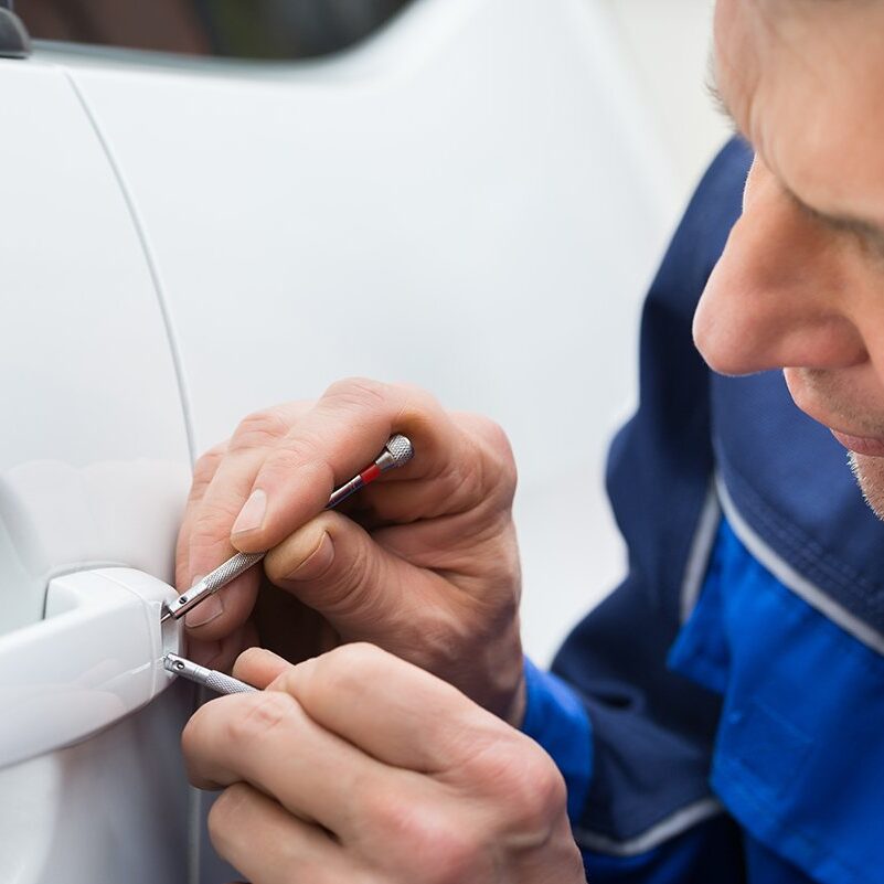 Hand Holding Lockpicker To Open Car Door Close-up Of Person Hand Holding Lockpicker To Open Car Door